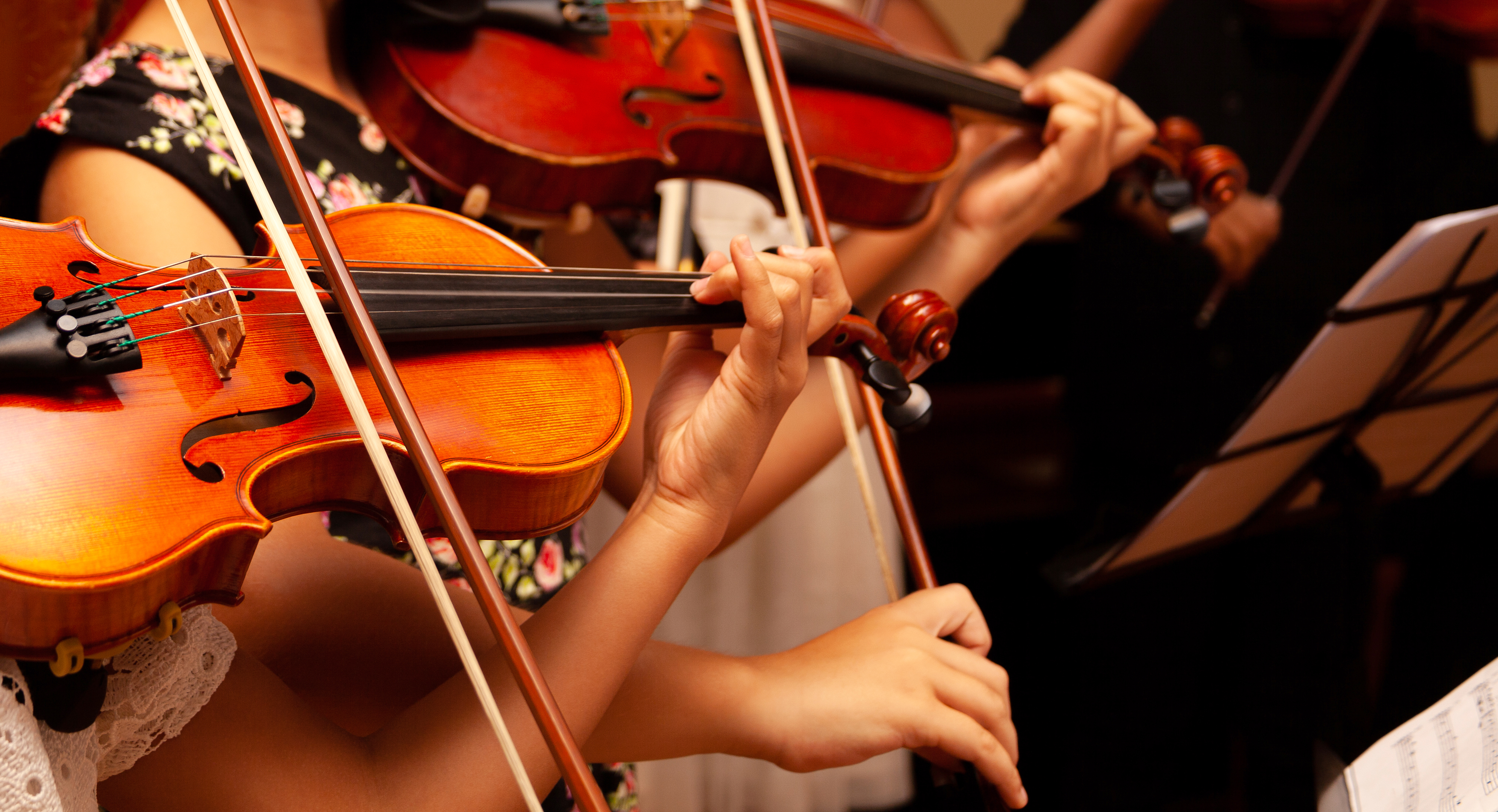 Group of children playing violins in an orchestra.