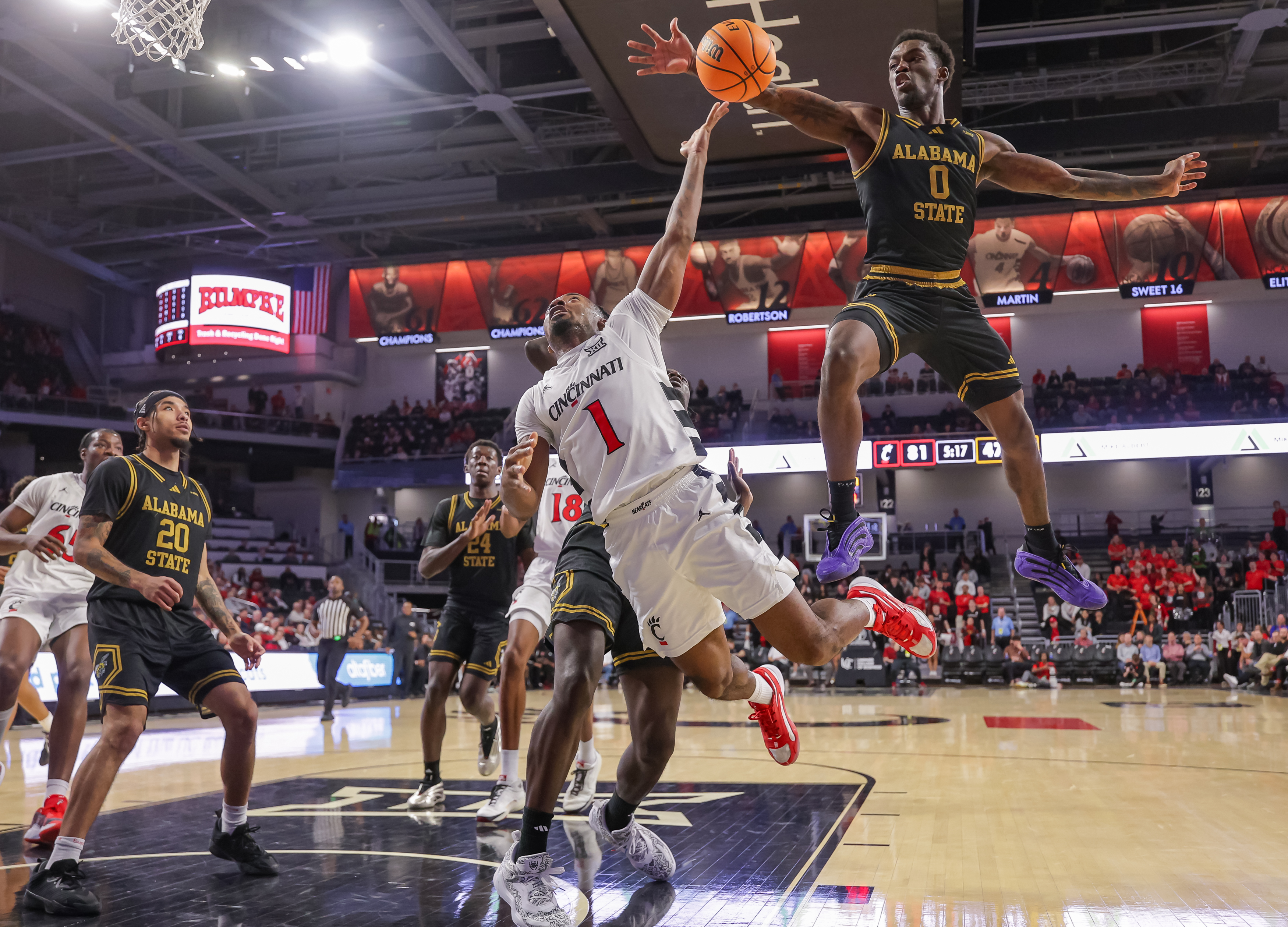 Day Day Thomas (#1 Cincinnati Bearcats) attempts a shot while Tyler Byrd (#0 Alabama State Hornets) blocks it.
