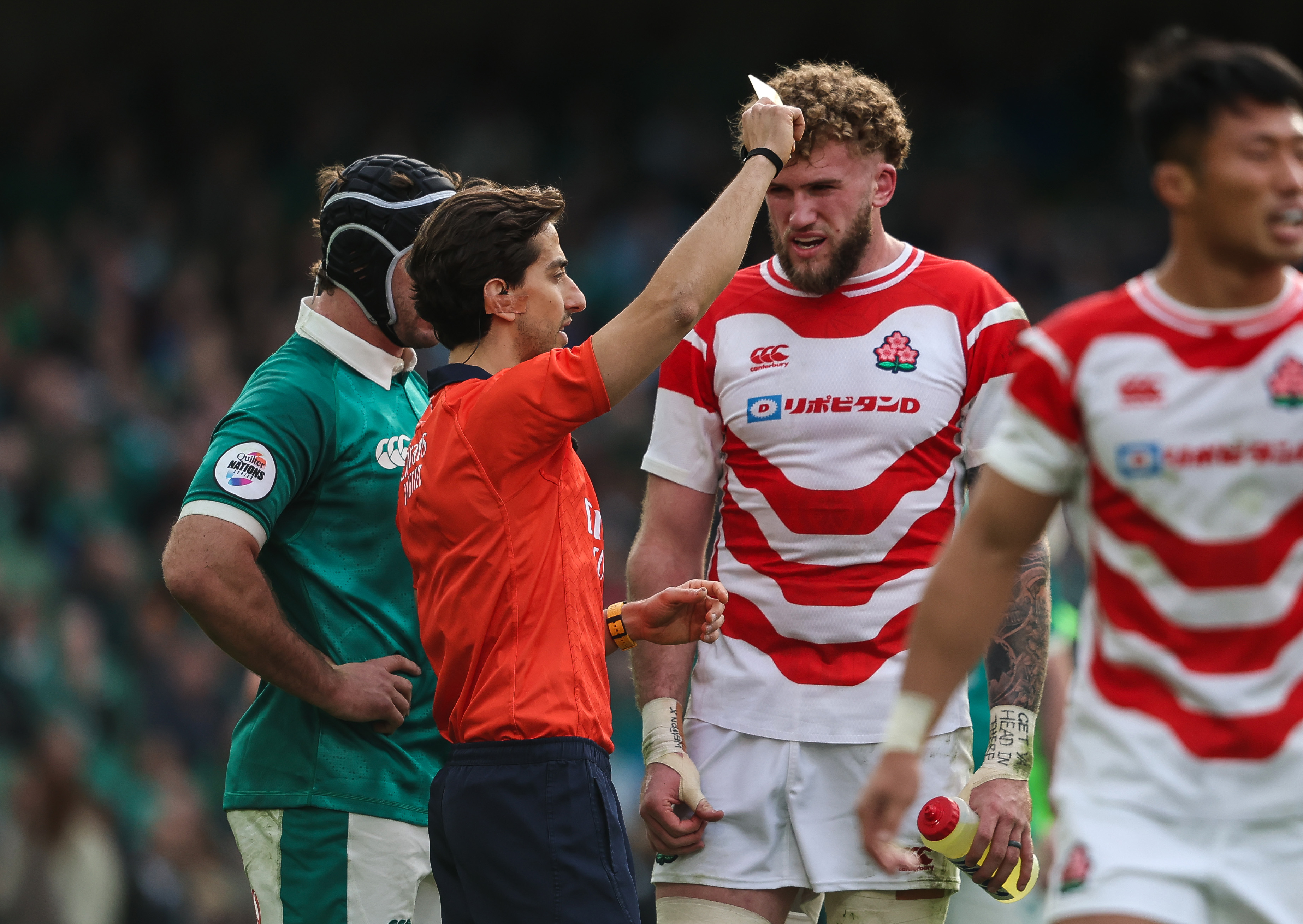 Referee Filippo Russo giving Japan's Charlie Lawrence a yellow card for a dangerous tackle.