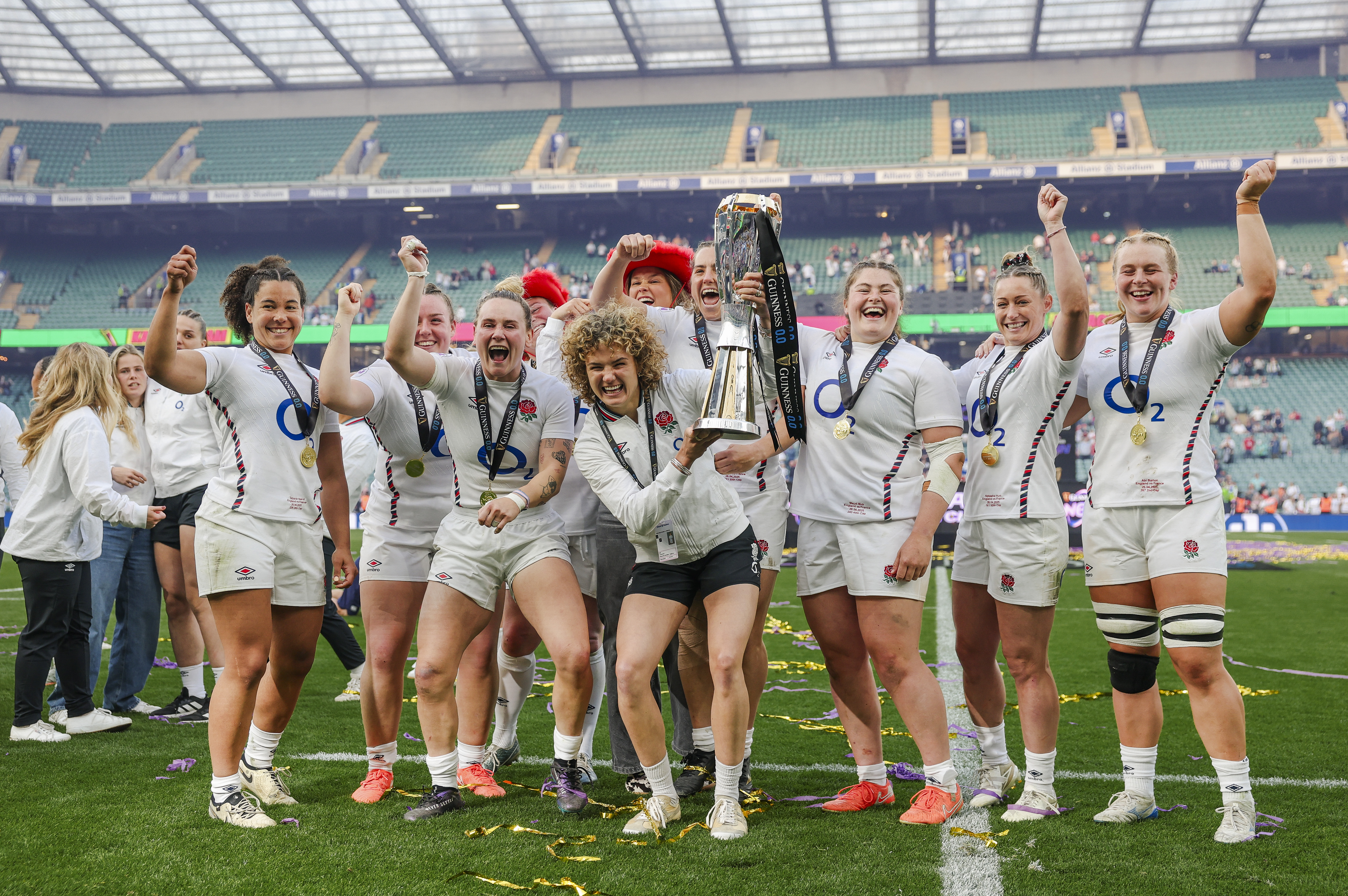 England women's rugby team celebrating their Six Nations Grand Slam victory with the trophy.