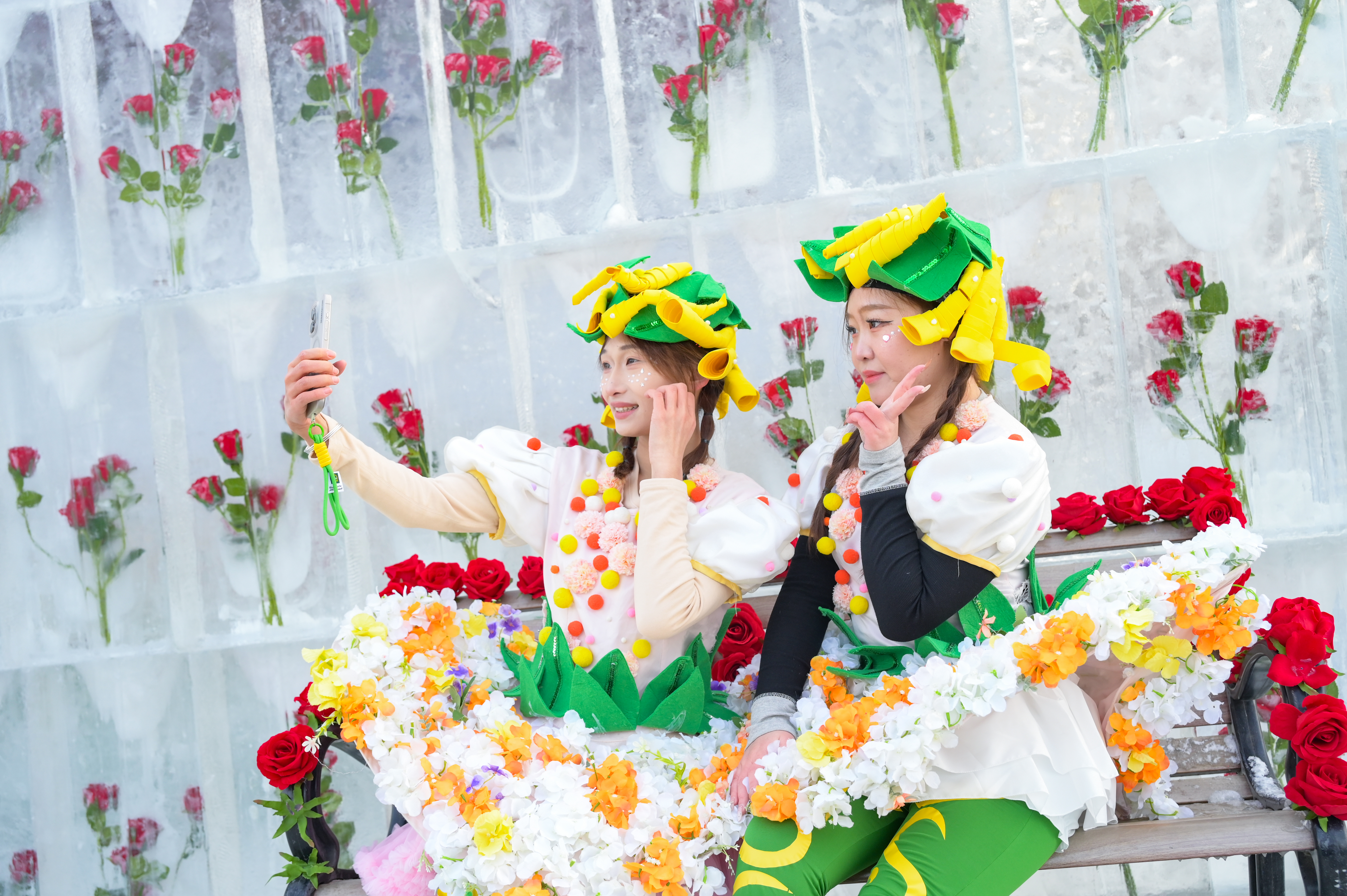 Tourists pose in front of a display of roses and fruit frozen in ice blocks in Shenyang, Liaoning Province.