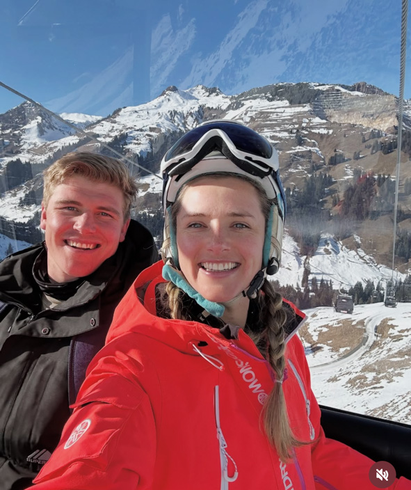 Ernst van Rhyn and his wife Bianca in a ski lift with mountains in the background.