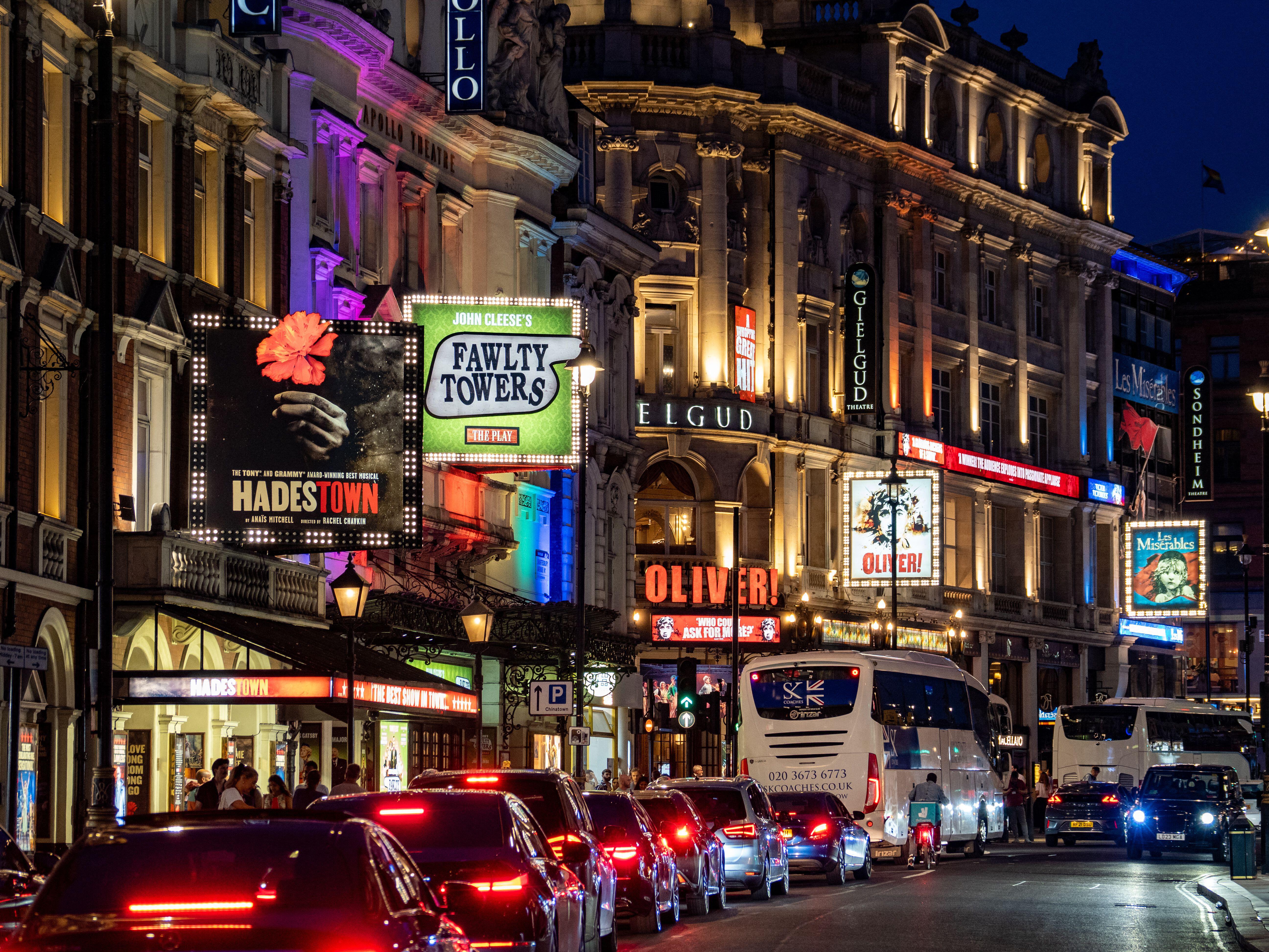 Facades of Lyric, Apollo, and Gielgud Theatres on Shaftesbury Avenue in London's West End at night.