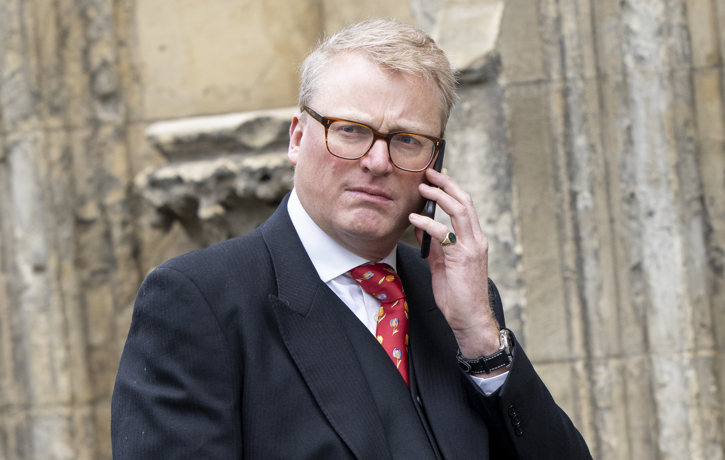 Tobyn Andreae, the King and Queen Consorts communications secretary, talks on a phone.