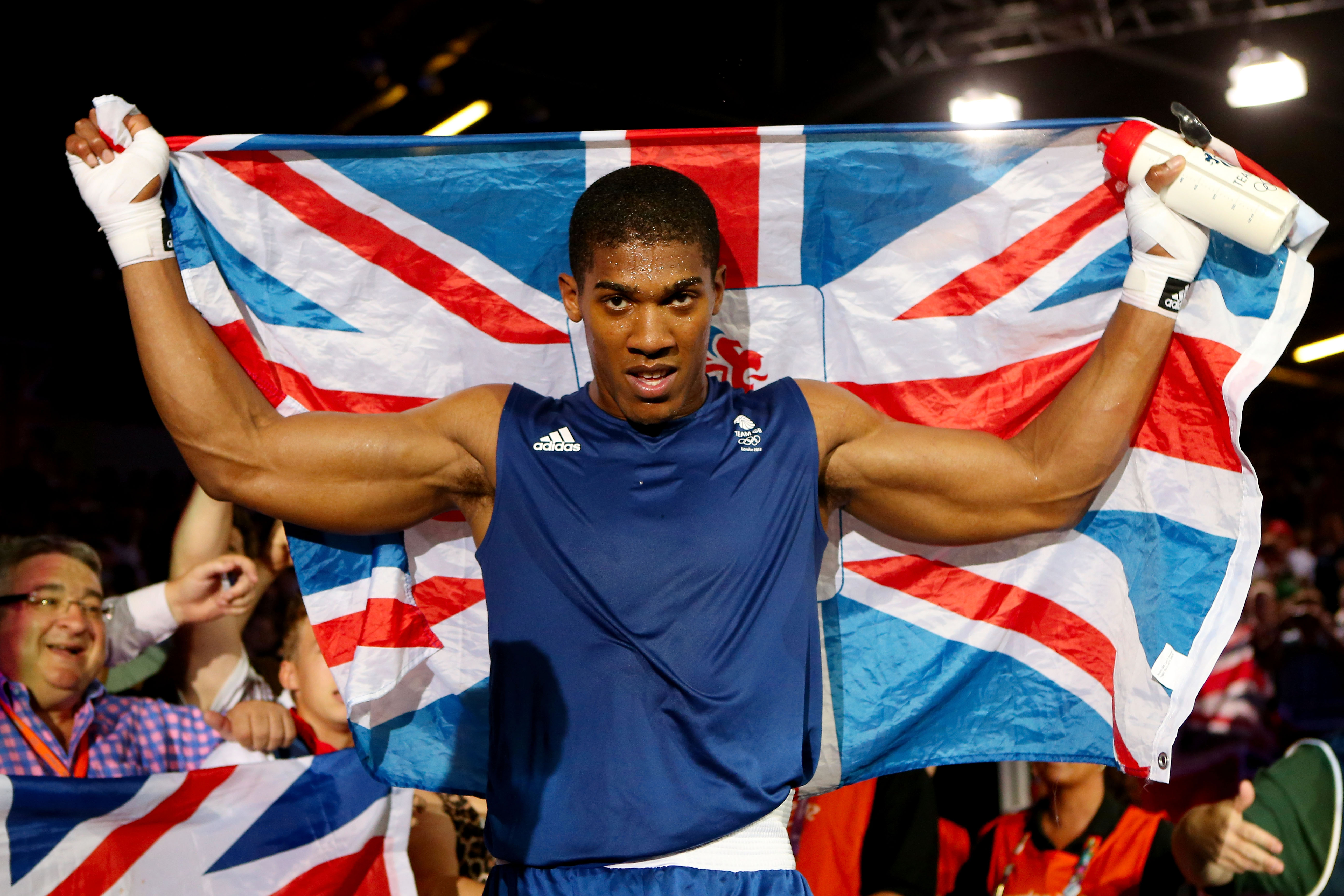 Anthony Joshua celebrates his victory at the London 2012 Olympic Games while holding the Union Jack flag.