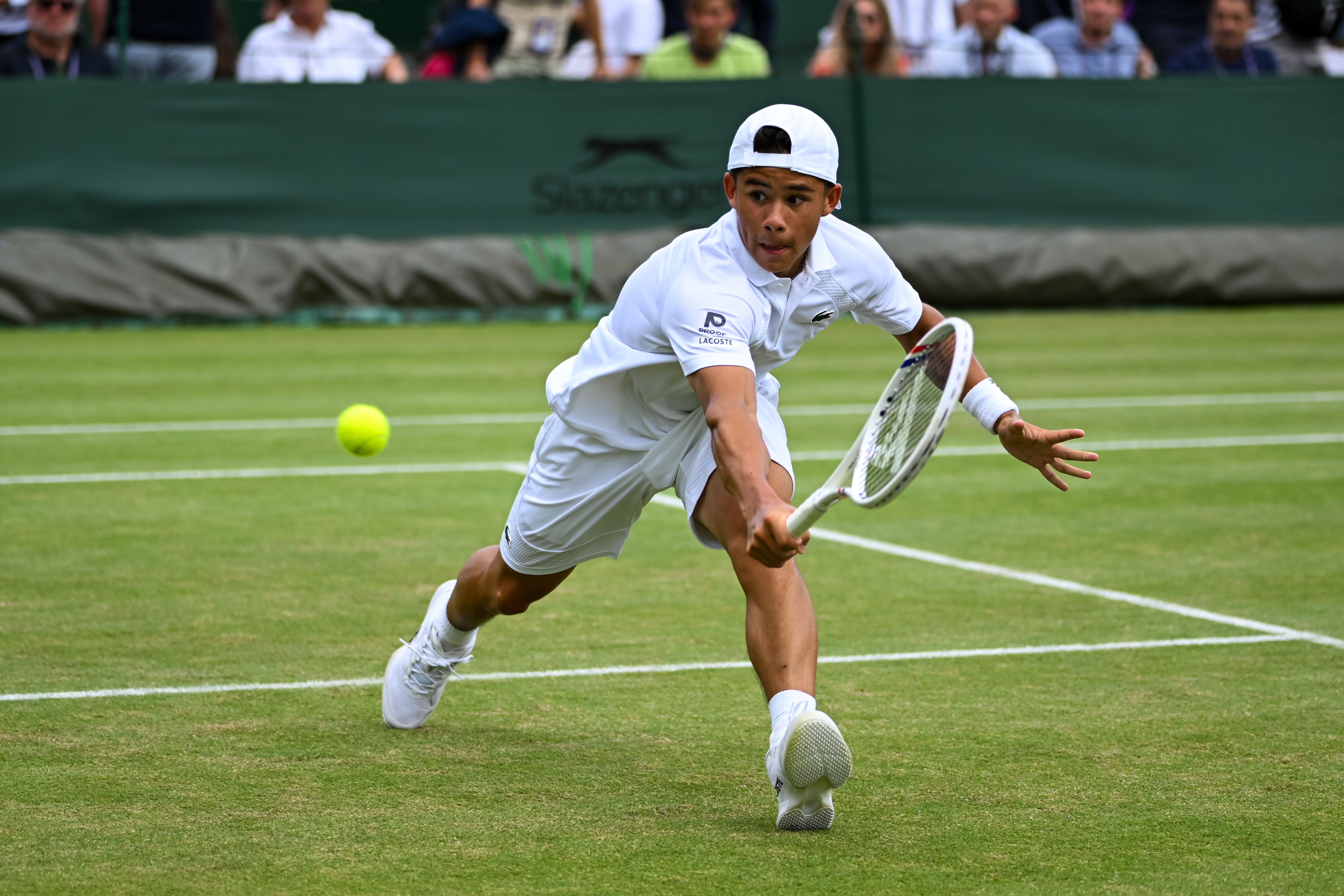 Benjamin Gusic-Wan in action during the Boy's Singles First Round match at Wimbledon 2025.