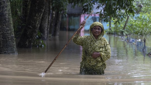 Locals wade through floodwaters in Feni, Bangladesh