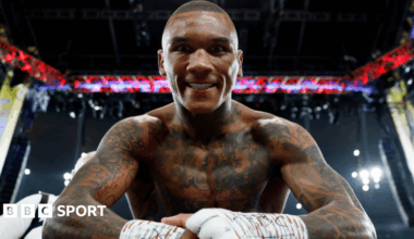 Conor Benn leans over the ropes smiling