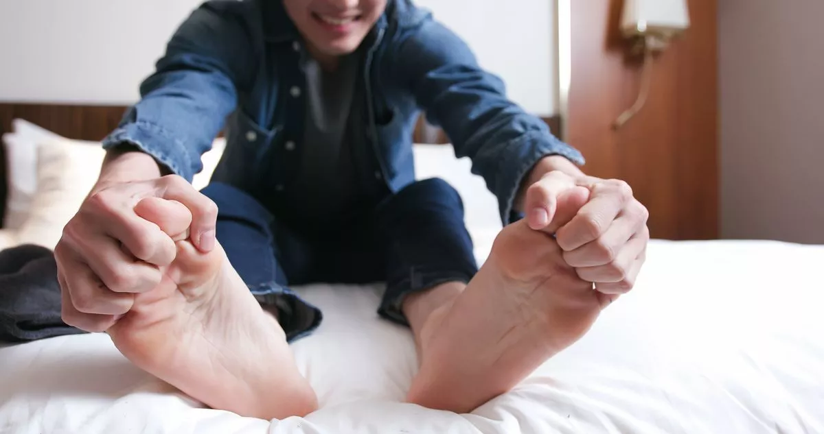 man scratch the itch by hand with athlete foot problem in the room