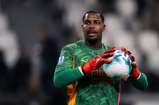 Mike Maignan holds the football.