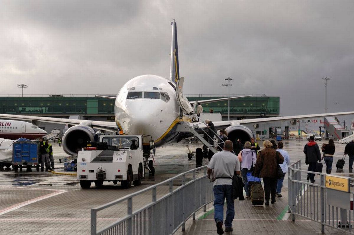 passengers with carry-on bags boarding a Ryanair Boeing 737-800 with a tug attached. (Photo by: aviation-images.com/Universal Images Group via Getty Images)