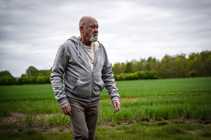 Bear Wolf walks alone through a field in Emmerdale