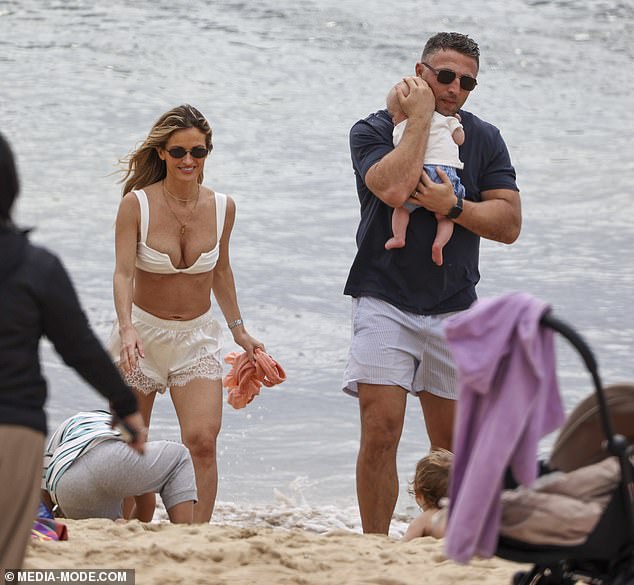 Nearby, Lucy, 33, cut a stylish figure as she kept a watchful eye on their daughter Robbie, two, while the toddler played along the shoreline