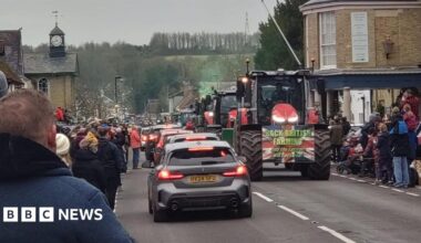Cars and tractors travelling on a village road