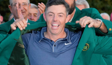 Rory McIlroy putting on green jacket after winning The Masters