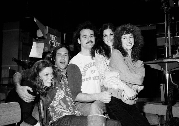 Comedian Chevy Chase, second from left, joins cast of NBC-TV's "Saturday Night Live," Feb. 16, 1978 in New York, where he first got his start with the "Not Ready For Prime Time Players." Others are, from left, Jane Curtin, Bill Murray, Gilda Radner, and Laraine Newman. Chase is doing a guest shot on the program. (AP Photo/Marty Lederhandler, File)