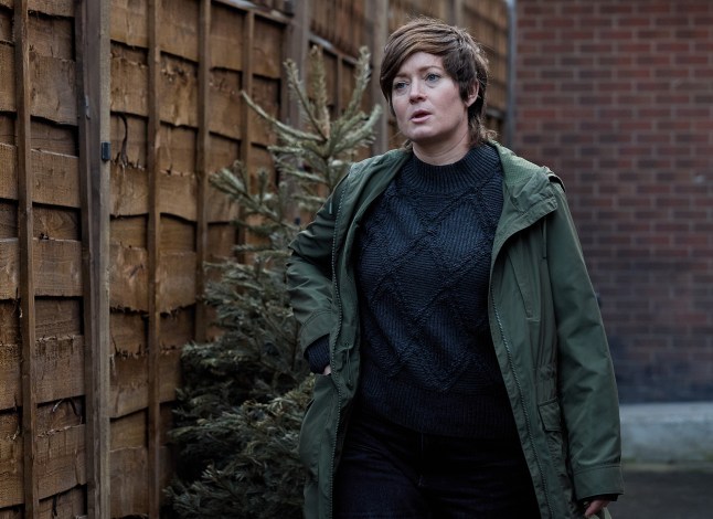 Becky stands in a garden with a troubled look on her face in Corrie