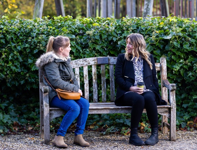 Charity Dingle and Vanessa Woodfield sitting on a bench in Emmerdale, talking to each other.