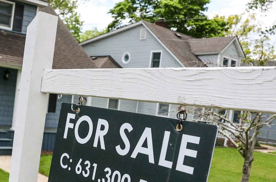 House with a "For Sale" sign in front, suggesting a real estate opportunity