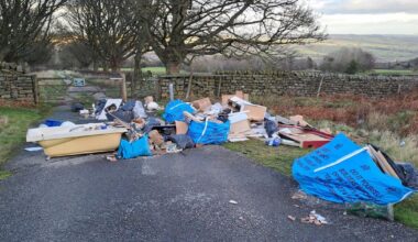 Bath and toilet amongst rubbish fly tipped on moorland road in Ilkley