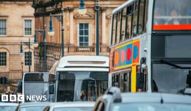 A close up picture of a queue of cars and buses on a street in Edinburgh driving towards the camera.