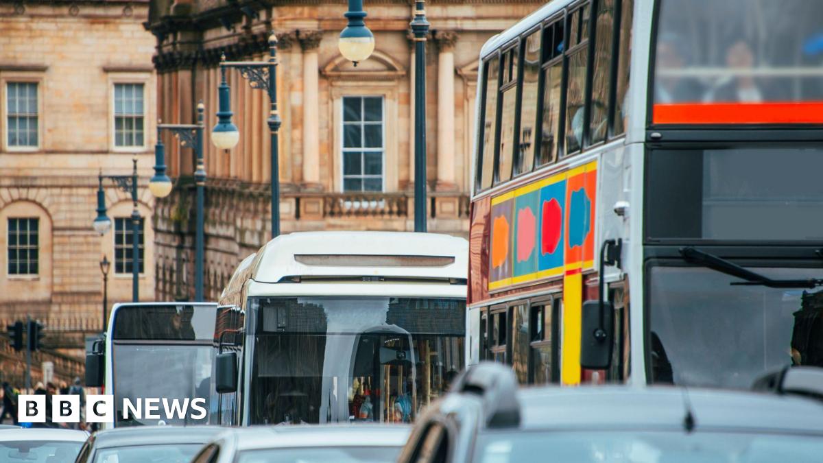 A close up picture of a queue of cars and buses on a street in Edinburgh driving towards the camera.