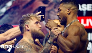 Jake Paul grabs Anthony Joshua's fist during a face-off