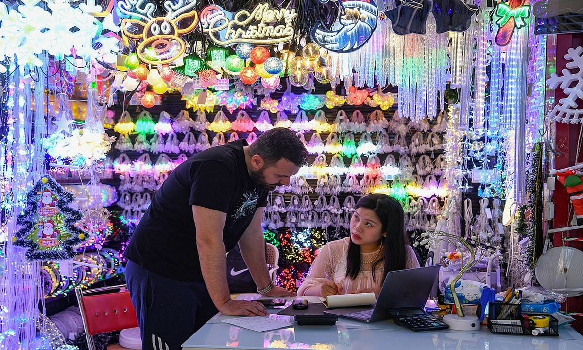 A foreign buyer selects Christmas decorations at the Yiwu International Trade Market in Yiwu, East China