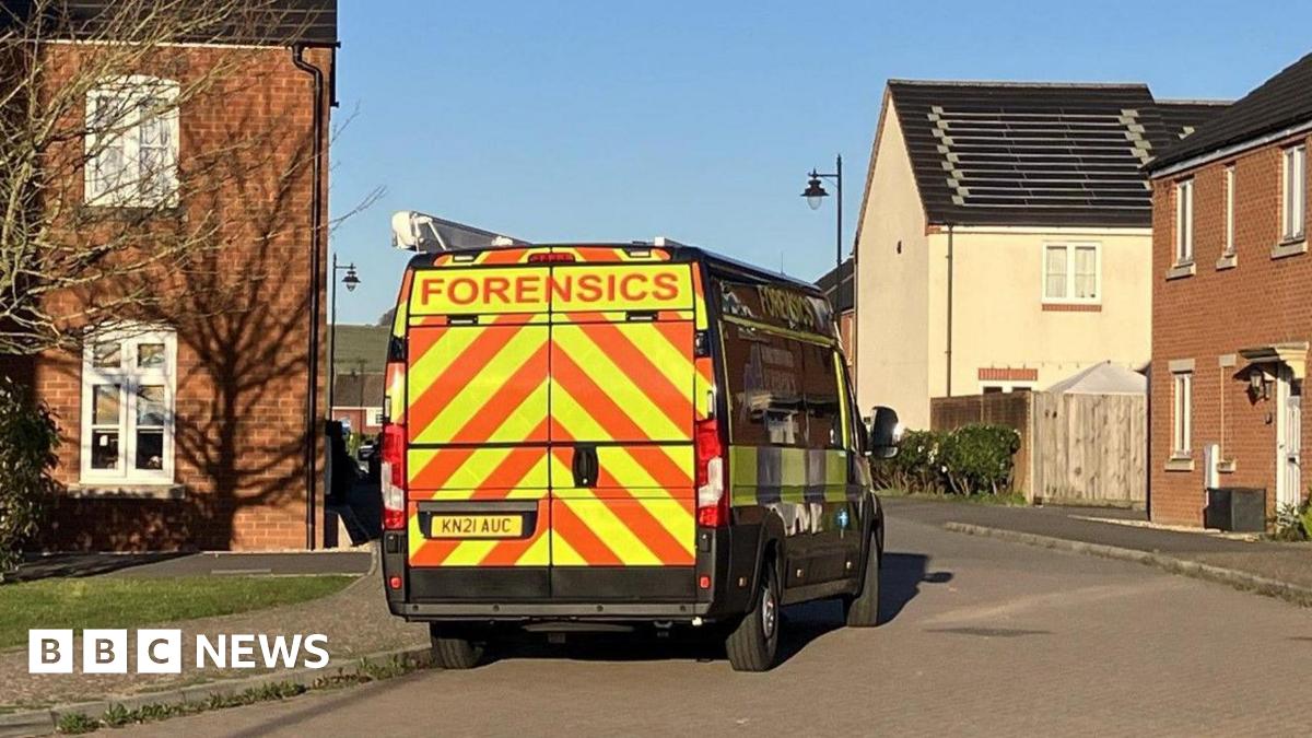 A police forensics van is parked on a residential estate on a sunny day.