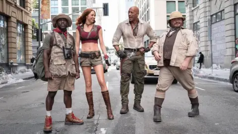 Instagram/@JumanjiMovie The four cast members of Jumanji in costume posing on a street