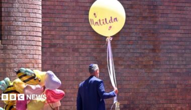 A man holds a balloon reading 'Matilda' during the funeral for 10-year-old Matilda a Bondi Beach shooting victim, at Chevra Kadisha Memorial Hall in Sydney