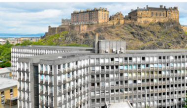 An aerial view of Argyle House, which is grey with lots of windows, designed in the brutalist style. Behind it is Edinburgh Castle.