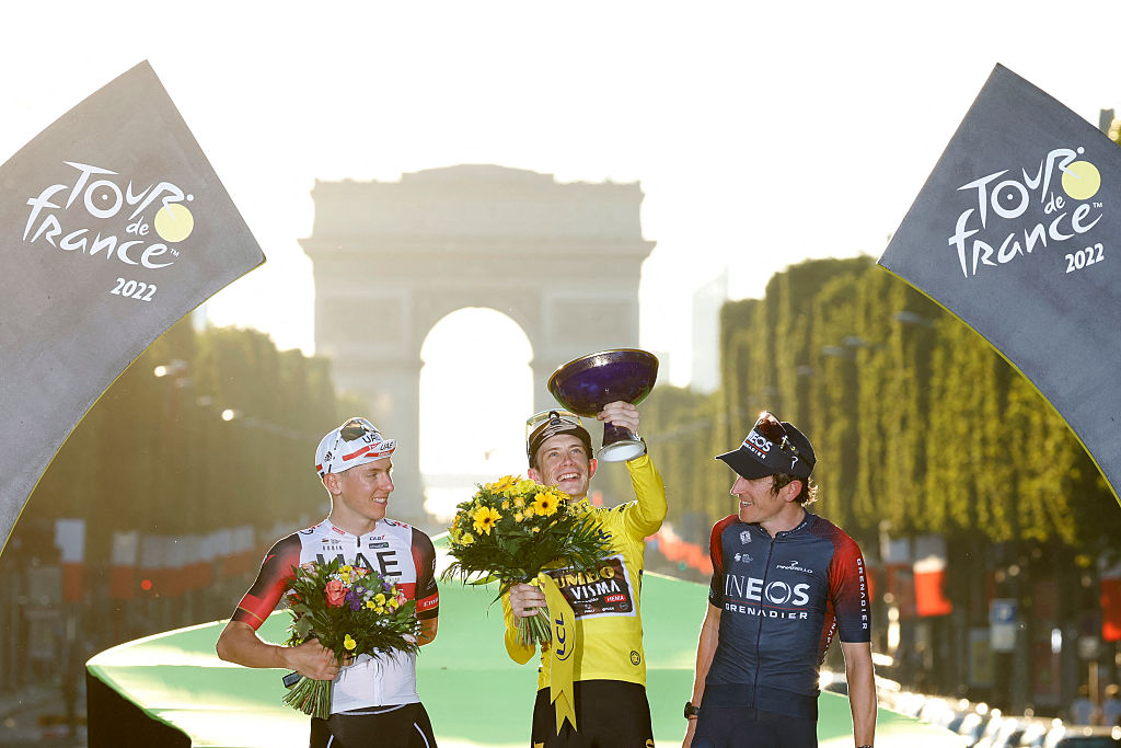 Jonas Vingegaard stands atop final Tour de France podium in 2022, flanked by Tadej Pogacar and Geraint Thomas