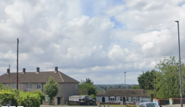 Google image of a Road with houses and a car