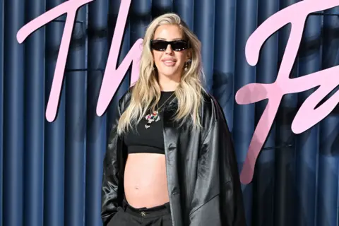 Getty Images Ellie goulding in black jacket, crop top and dark glasses, revealing her baby bumb