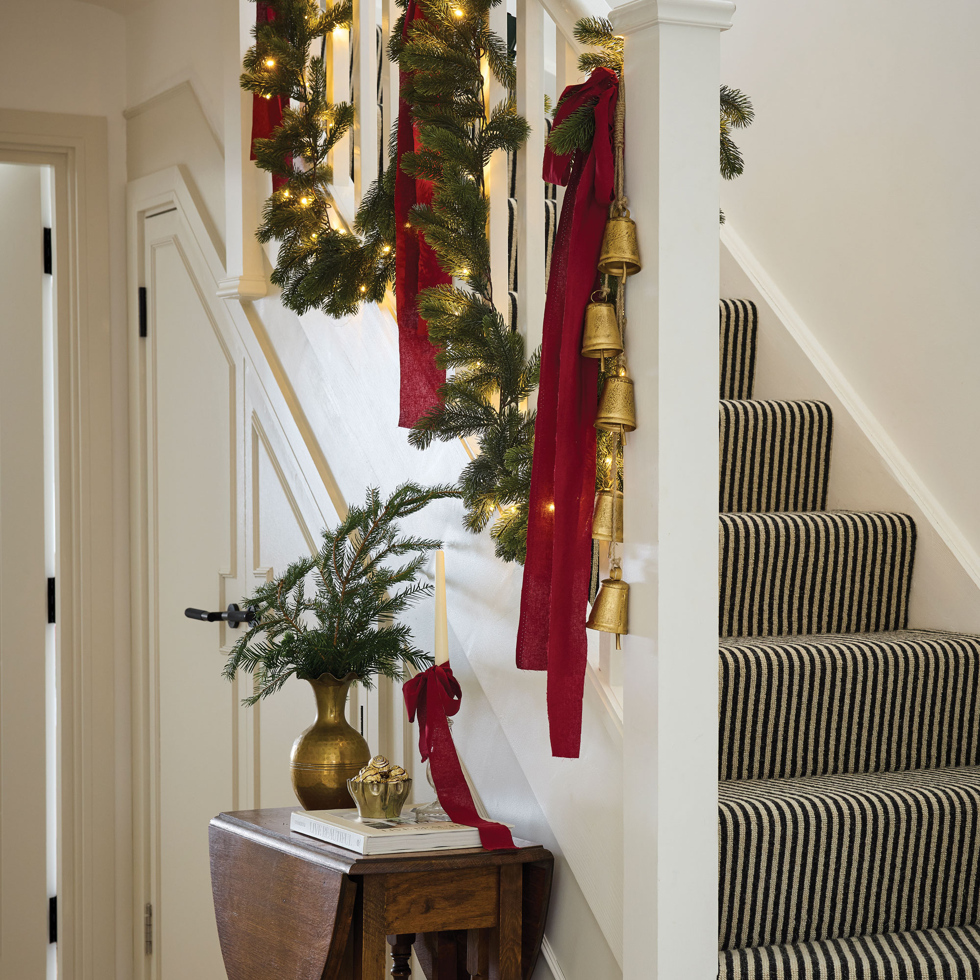 White hallway with black and white striped stair runner
