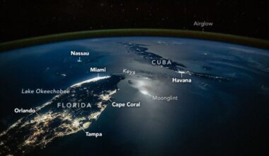 A photograph of the tip of Florida and nearby Cuba from space, with lights from cities illuminating the surface of the planet, labeled cities like Orlando and Tampa are seen as well as a green surface over Earth's labeled airglow
