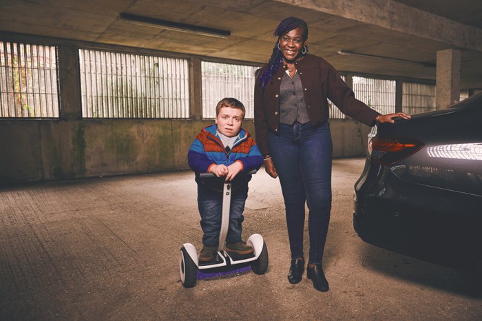 Dame Maggie Aderin-Pocok and Lenny Rush star in Finding Father Christmas; they are photographed in a car park