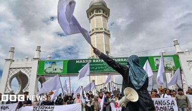 Activists protest with white flags in front of a mosque in Banda Aceh to demand that the Indonesian government opens the door to foreign aid