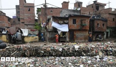 Houses situated along a canal filled with plastic garbage in New Delhi on 8 September, 2024