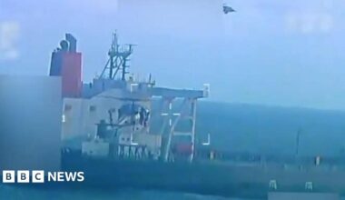 Maduro, speaking into a microphone and holding an old sword. He's wearing a light blue shirt and a straw hat.