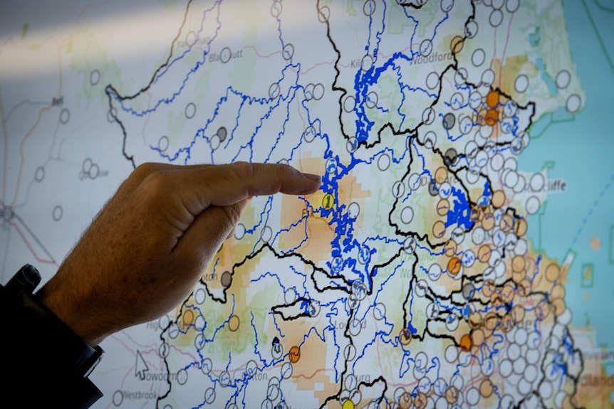 A finger pointing at a spot on a digitised map of south-east queensland