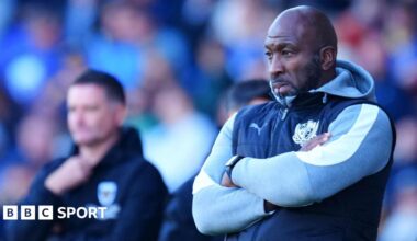 Darren Moore stand with his arms crossed watching on from the touchline during a game