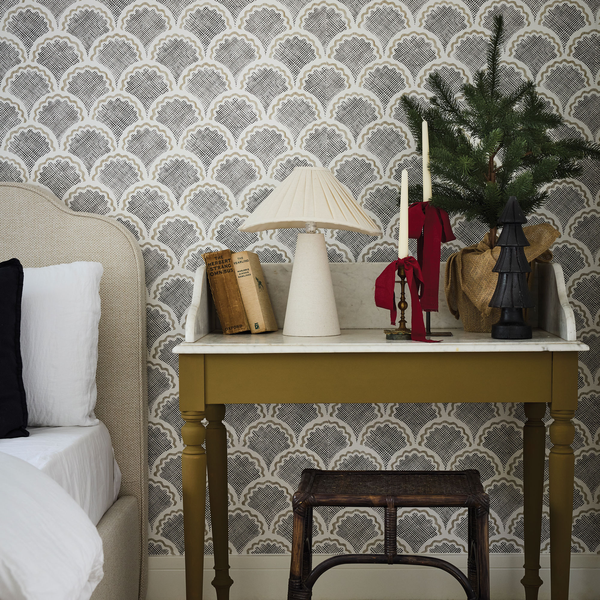 Bedroom with a small vanity table dressed with cabdel sticks, lamps and a small tree