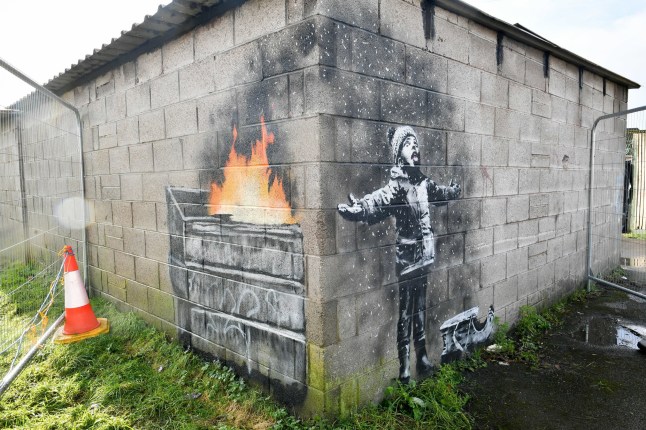 File photo dated 20/12/18 of Banksy's Season's Greetings which depicts a message about the impact of pollution on communities and appeared on the outside of a steelworker's private garage in Taibach, Port Talbot on December 19 2018. The mural painted by world-renowned street artist Banksy is to be removed from its home in Wales and taken to a secure location after attempts by "fanatics" to damage the artwork, its owner has said. Issue date: Tuesday February 8, 2022. PA Photo. It was bought by art dealer John Brandler who agreed to keep the piece in the South Wales town for three years, and the Welsh Government later paid to have it moved to an unoccupied shop in Ty'r Orsaf so it could be viewed by the public. See PA story ARTS Banksy. Photo credit should read: Ben Birchall/PA Wire
