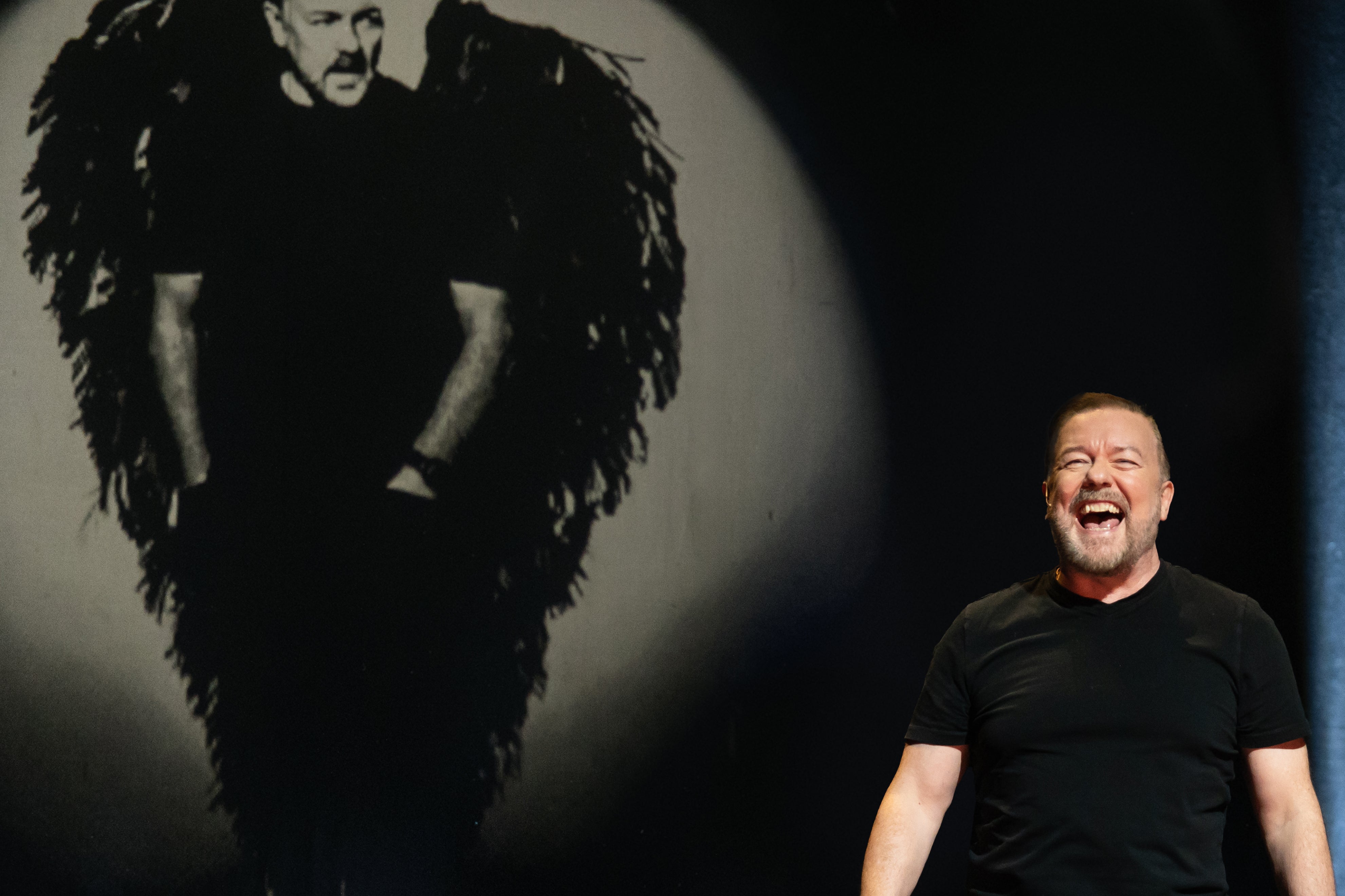Ricky Gervais laughs onstage during his latest Netflix special 'Mortality'