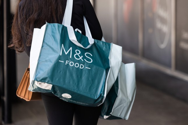 A customer carries food from a Marks & Spencer Group Plc (M&S) food hall in London, UK, on Friday, May 17, 2024. Marks & Spencer are due to report their latest earnings on Wednesday, May 22. Photographer: Chris Ratcliffe/Bloomberg via Getty Images