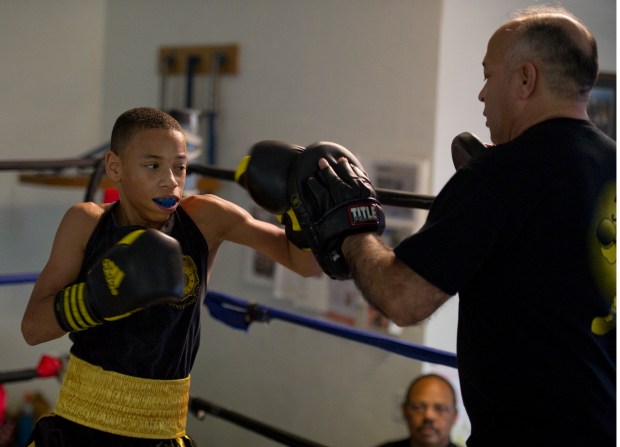Andrew Strode works out in the ring with coach Stephen Blea at the Denver Police Brotherhood Youth Boxing Club on April 7, 2011. (Photo by John Leyba/The Denver Post)