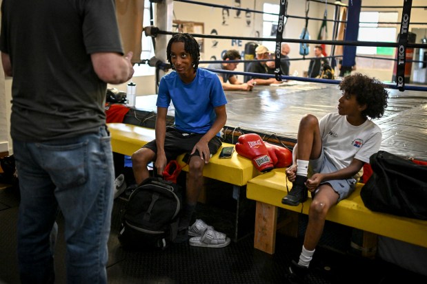 Coach Mike Hewett talks to brothers Nabue and Abraham Daniel at the Denver Police Brotherhood Youth Boxing club on Monday, Dec. 22, 2025. (Photo by AAron Ontiveroz/The Denver Post)