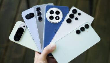 Someone holding a lot of Android phones, including ones from Google, Samsung, and OnePlus.